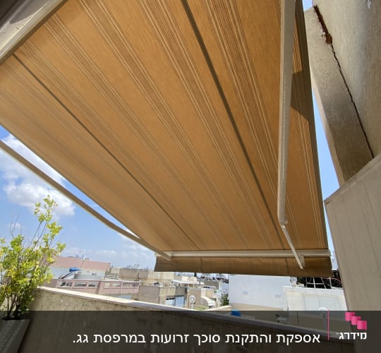 סוכך חום נפתח מעל מרפסת עם נוף עירוני